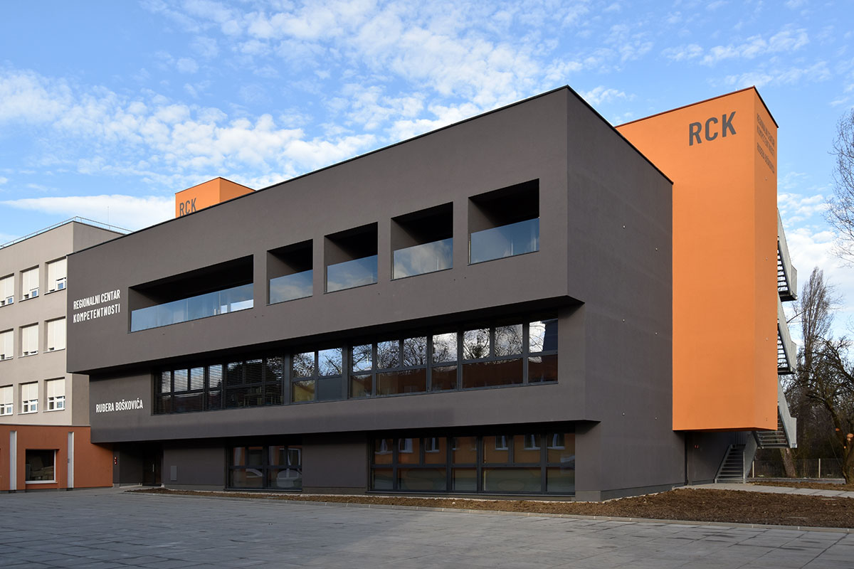 pogled na sivo narandžastu zgradu sa prozorima