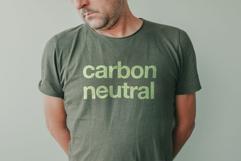 muškarac nosi zelenu majicu s ugljično neutralnim tekstom