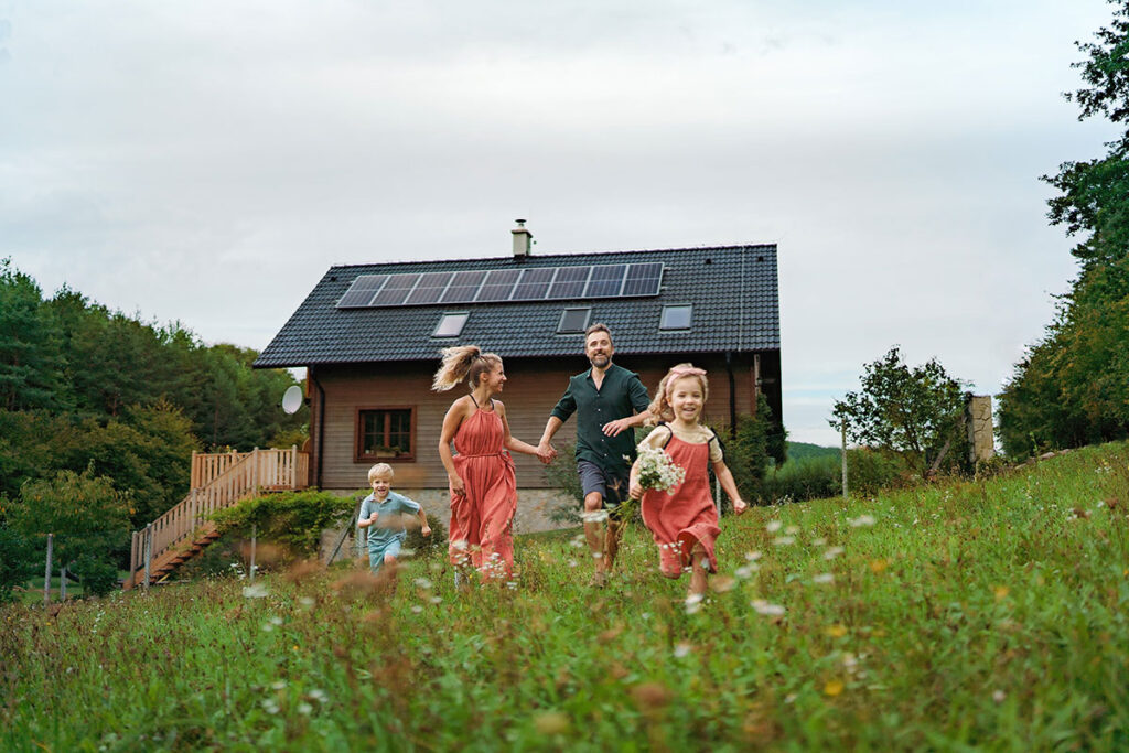 porodica ispred kuce sa solarnim panelima na krovu