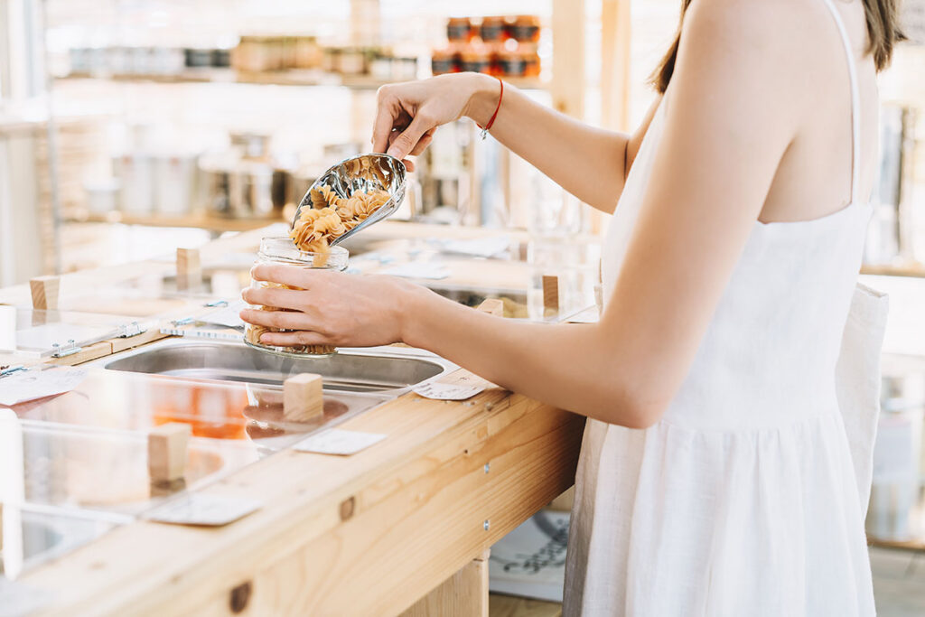 zero waste shop žena koja kupuje suhu hranu u plastici